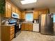 Spacious kitchen featuring oak cabinets, granite countertops, stainless steel appliances, and tile backsplash at 123 Cross Creek Dr, Statesville, NC 28625