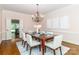 Elegant dining room with chandelier, modern table setting, and view to backyard at 1233 Weymouth Ln, Charlotte, NC 28270
