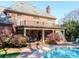 Elegant brick home with a covered patio, balcony, and pool view at 1233 Weymouth Ln, Charlotte, NC 28270