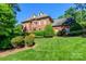 Beautiful two-story brick home with lush lawn and mature landscaping at 1233 Weymouth Ln, Charlotte, NC 28270