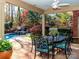 This covered patio has an outdoor dining area with a waterfall and lush landscaping at 1233 Weymouth Ln, Charlotte, NC 28270