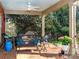 This covered patio has an outdoor living area, ceiling fan, and overlooks the landscaping at 1233 Weymouth Ln, Charlotte, NC 28270