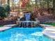 Beautiful in-ground pool with a rock waterfall feature and stone surround at 1233 Weymouth Ln, Charlotte, NC 28270