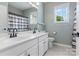 Bathroom with double sink vanity, white cabinets, light gray walls and floors at 14220 Stewarts Bend Ln, Charlotte, NC 28277