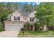 Charming two-story home with a well-manicured lawn, red door, and attached two car garage at 14220 Stewarts Bend Ln, Charlotte, NC 28277