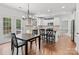 Bright kitchen with an island, stainless steel appliances, and hardwood floors connected to dining area at 14220 Stewarts Bend Ln, Charlotte, NC 28277