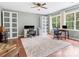 Bright home office featuring hardwood floors, built-in cabinets, and large windows with views of the surrounding greenery at 14220 Stewarts Bend Ln, Charlotte, NC 28277