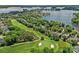 Aerial view of a home situated on a golf course with scenic lake views in the background at 17040 Jetton Rd, Cornelius, NC 28031