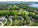 Aerial view of a stately home with lush landscaping, a nearby golf course, and stunning lake views, showcasing luxury living at 17040 Jetton Rd, Cornelius, NC 28031