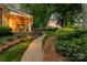 Stone pathway through lush greenery and landscaping leading to a covered patio, perfect for enjoying the peaceful backyard at 17040 Jetton Rd, Cornelius, NC 28031