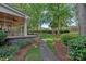 Inviting covered patio with stone flooring, columns, and a peaceful view of the landscaped backyard at 17040 Jetton Rd, Cornelius, NC 28031
