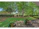 Serene backyard view featuring lush landscaping, a brick patio, and a distant golf course view at 17040 Jetton Rd, Cornelius, NC 28031