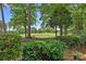 Beautiful backyard featuring manicured hedges, mature trees, and golf course views at 17040 Jetton Rd, Cornelius, NC 28031