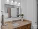 Bright bathroom featuring a vanity with granite countertop, classic fixtures and a large mirror at 17040 Jetton Rd, Cornelius, NC 28031