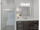 Bright bathroom featuring glass shower, modern vanity with marble countertop and stylish fixtures at 17040 Jetton Rd, Cornelius, NC 28031