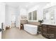 Bright bathroom with a freestanding tub, large window, and neutral-toned tile at 17040 Jetton Rd, Cornelius, NC 28031