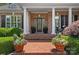 Charming front porch with brick steps, white columns, and colorful potted flowers create an inviting entry at 17040 Jetton Rd, Cornelius, NC 28031