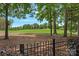 Beautiful golf course view framed by trees and a decorative fence enhancing this home's appeal at 17040 Jetton Rd, Cornelius, NC 28031