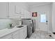 Well-organized laundry room with modern appliances, cabinetry, quartz countertop and stylish tile backsplash at 17040 Jetton Rd, Cornelius, NC 28031