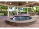 Covered patio featuring a round water fountain surrounded by brick pavers and manicured landscaping at 17040 Jetton Rd, Cornelius, NC 28031