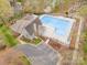 Aerial view of the community pool, clubhouse, parking, landscaping, and surrounding trees at 1713 Mt Isle Harbor Dr, Charlotte, NC 28214