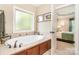 A soaking tub with tile surround and window offers a relaxing retreat, next to the main bedroom at 1713 Mt Isle Harbor Dr, Charlotte, NC 28214