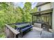 Outdoor deck with dining area, bench seating, and serene views of the surrounding trees at 1713 Mt Isle Harbor Dr, Charlotte, NC 28214
