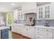 A close up of the kitchen with white cabinets, tile backsplash, and quartz countertops at 1713 Mt Isle Harbor Dr, Charlotte, NC 28214