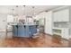 Bright kitchen with white cabinets, stainless steel appliances, a stylish blue island, and hardwood flooring throughout at 1713 Mt Isle Harbor Dr, Charlotte, NC 28214