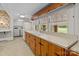 Vintage kitchen featuring long counter top, wood cabinets, and a large window overlooking the backyard at 182 Ryan St, Salisbury, NC 28144
