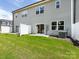 Backyard with green grass, a white fence, and the back of a gray house at 2021 Endeavor Run, Charlotte, NC 28269
