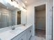 Bright bathroom featuring a double vanity, a large mirror and a glass shower at 2021 Endeavor Run, Charlotte, NC 28269