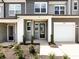 Stylish townhome entrance featuring a covered porch, modern door, and landscaping at 2021 Endeavor Run, Charlotte, NC 28269