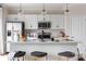 Bright kitchen with white cabinetry, a stainless steel refrigerator, and a central island with seating at 2021 Endeavor Run, Charlotte, NC 28269