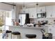 Modern kitchen featuring white cabinets, stainless steel appliances, and a breakfast bar with pendant lighting at 2021 Endeavor Run, Charlotte, NC 28269