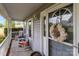 Charming front porch with rocking chairs and seasonal wreath create welcoming curb appeal at 230 Castle Keep Rd, Salisbury, NC 28146