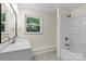 Bathroom with a white vanity and shower tub, and a window providing natural light at 300 N Ervin Ave, Newton, NC 28658