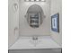 Well-maintained bathroom with a modern sink, oval mirror, and decorative shelf, combining practicality with a touch of style at 1300 Larchmont Pl # 306, Salisbury, NC 28144