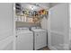 Convenient laundry closet equipped with a washer, dryer, and shelving for efficient and organized laundry management at 1300 Larchmont Pl # 306, Salisbury, NC 28144