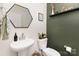 Stylish powder room features a pedestal sink, hexagon mirror, and modern decor at 330 Hyssop Ct, Fort Mill, SC 29715