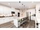 Modern kitchen featuring white cabinets, stainless steel appliances, granite countertops, and a spacious center island with seating at 330 Hyssop Ct, Fort Mill, SC 29715