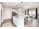Well-lit kitchen featuring white cabinets, stainless steel appliances, a large island with seating, and modern pendant lighting at 330 Hyssop Ct, Fort Mill, SC 29715