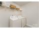 This laundry room offers practical convenience, featuring a washer, dryer, and ample shelving for storage solutions at 330 Hyssop Ct, Fort Mill, SC 29715