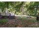 Spacious backyard featuring a wooden deck, fire pit, and mature trees for shade and privacy at 3332 Celanese Rd, Rock Hill, SC 29732