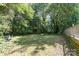 Lush backyard with mature trees, shed, and cozy fire pit, perfect for relaxation and outdoor activities at 3332 Celanese Rd, Rock Hill, SC 29732