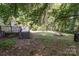 Spacious backyard featuring a wooden deck, fire pit, and mature trees for shade and privacy at 3332 Celanese Rd, Rock Hill, SC 29732