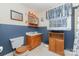 Bright bathroom features a classic vanity, storage cabinet, and a window with decorative curtains at 3332 Celanese Rd, Rock Hill, SC 29732