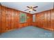 Spacious bedroom with wood paneled walls, neutral carpet, and two windows offering ample natural light at 3332 Celanese Rd, Rock Hill, SC 29732