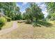 Expansive front yard with a garden bed, mature shade trees and a sidewalk to the home at 3332 Celanese Rd, Rock Hill, SC 29732