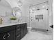 Modern bathroom with sleek black vanity, round mirrors, and glass-enclosed shower with black hardware at 3417 Chilham Pl, Charlotte, NC 28226